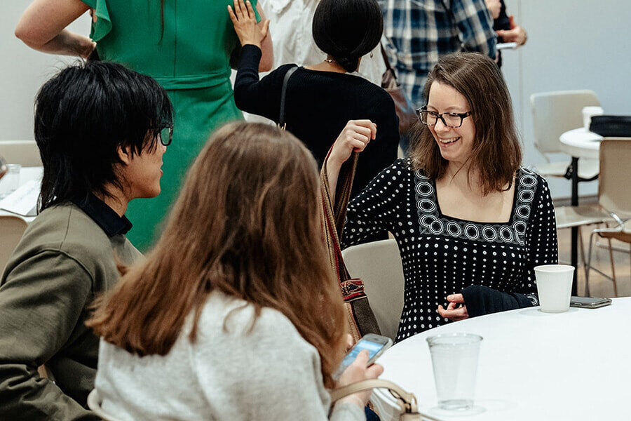 Adult Sunday School Classes in Dallas with church members connecting and talking around tables before class.
